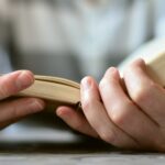 Hände halten eine aufgeschlagene Bibel