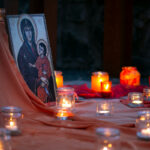kleiner Altar mit rotem Tuch und einigen Windlichtern. Rechts vor dem Altar ist eine Ikone der Gottesmutter Maria.