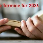 Hände halten ein aufgeschlagenes Buch